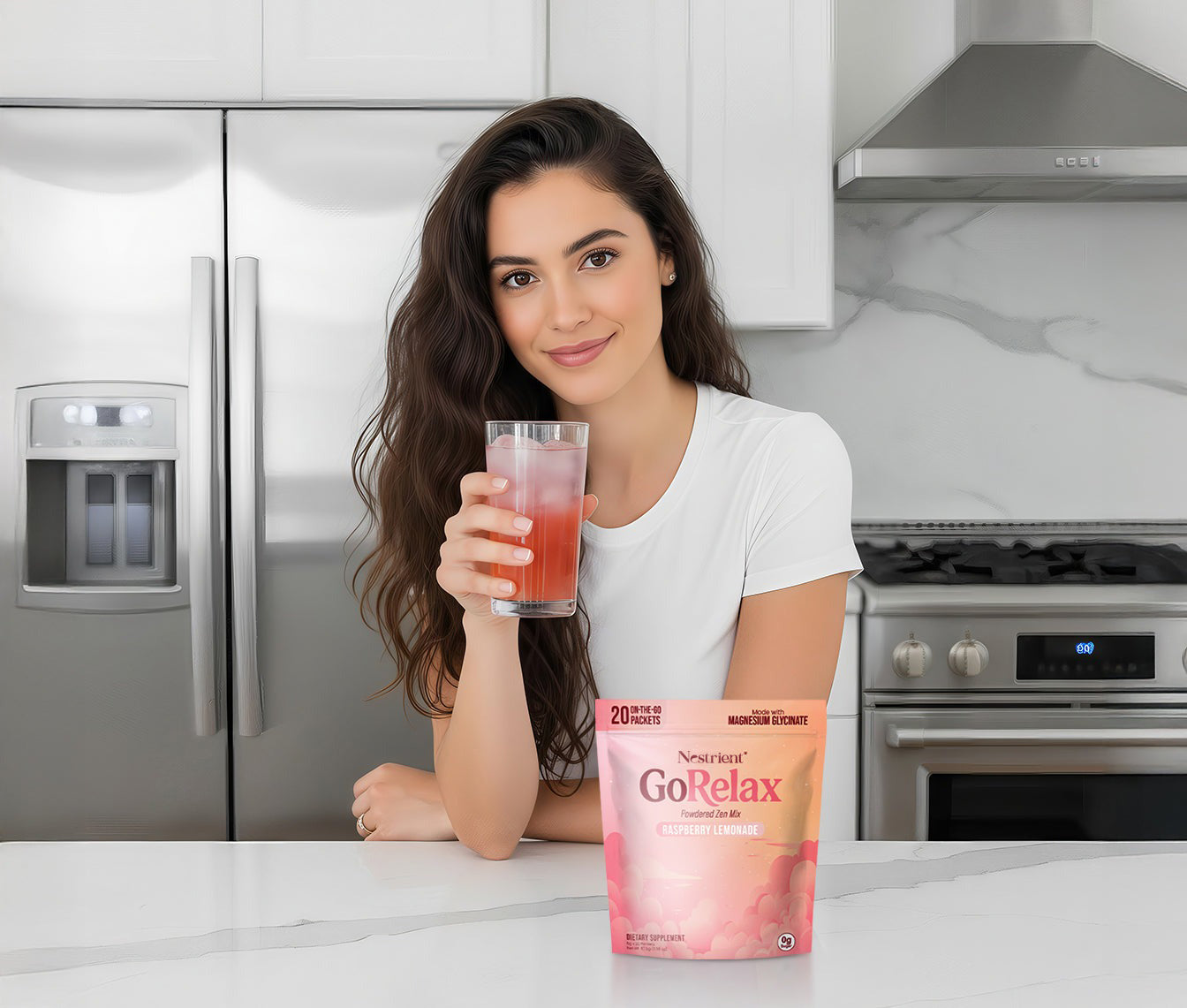 Woman holding a glass of pink drink next to a package of GoRelax supplement in a kitchen.