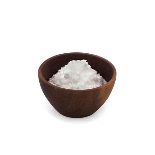 Brown bowl filled with white salt on a white background