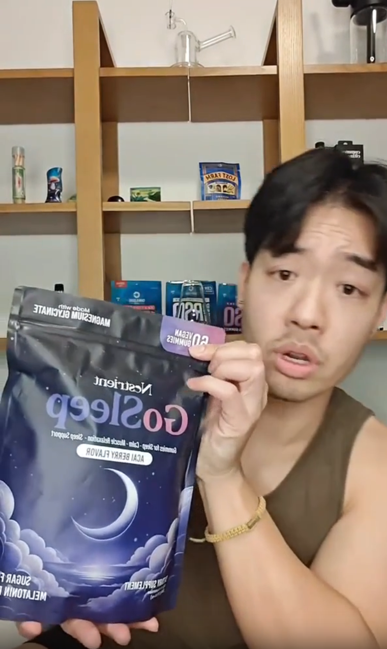 Person holding a package of 'GoSleep' in front of a shelf with various items.