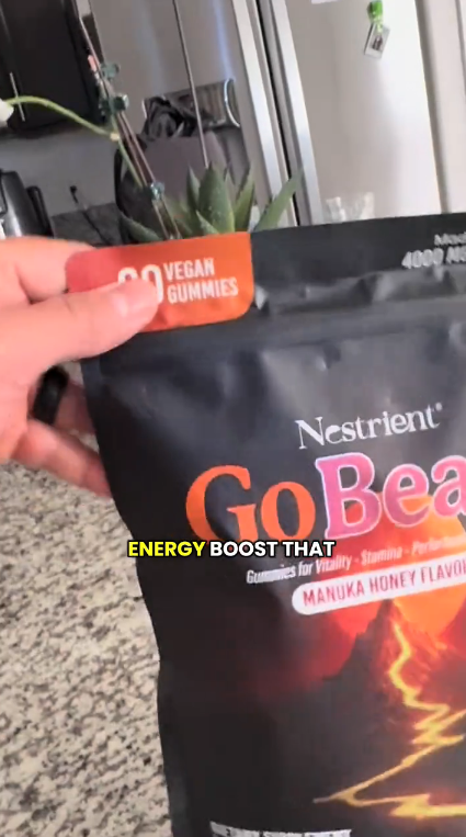 Hand holding a package of Nestrient GoBeats energy gummies.