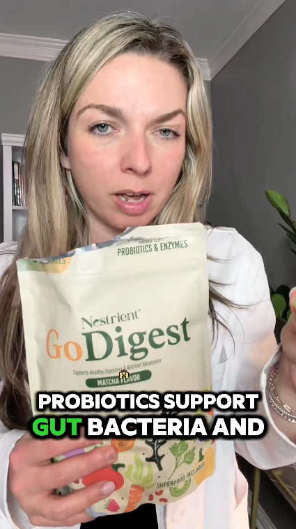 Woman holding a 'GoDigest' probiotics package with text overlay.
